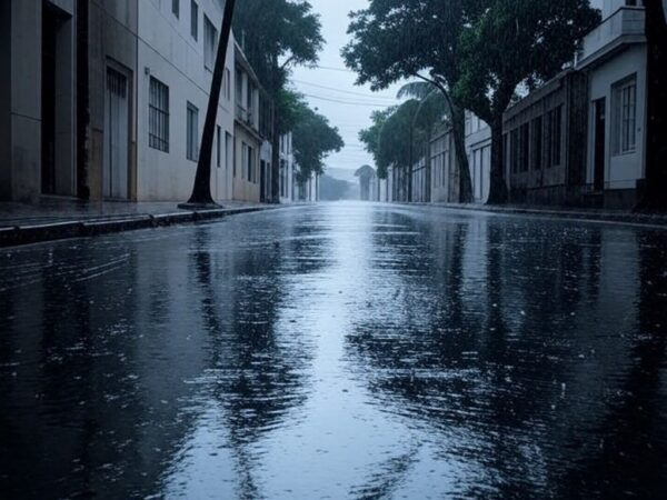 Rua brasileira sob chuva intensa, com nuvens escuras e poças d'água, ilustrando alerta laranja do Inmet para chuvas fortes em cinco estados.