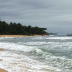 Praia de Ponta Negra em Maricá com mar agitado, representando desaparecimento da embarcação Funelli com pescadores.