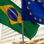 Bandeiras do Brasil e UE em frente ao Ministério da Agricultura em Brasília, simbolizando acordo Mercosul-UE e reuniões na Europa.