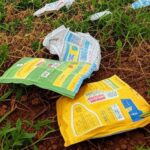 Lavoura de soja no Brasil com embalagens de insumos agrícolas falsificados espalhadas no solo.