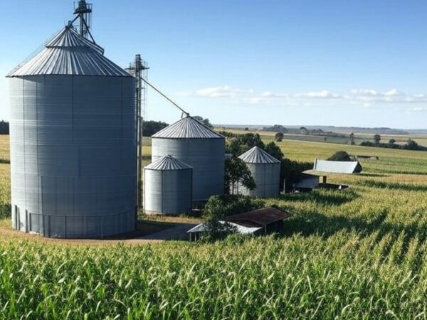 Paisagem agrícola no norte do Paraná com silos e campos de cultivo, representando aquisição de unidades pela Coamo.
