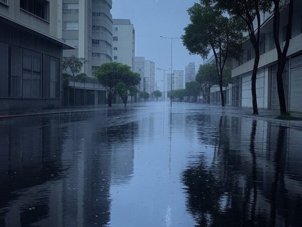 Rua inundada por chuvas intensas e temporais em cidade brasileira, com céu nublado e poças d'água.