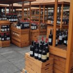 Feira em Curitiba com caixas de bebidas alcoólicas irregulares apreendidas pelo MAPA, em ambiente urbano paranaense.