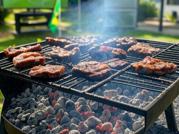 Churrasqueira com carnes premium grelhando em quintal brasileiro, simbolizando alta de churrascos na Copa 2026.