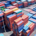 Porto brasileiro com contêineres e bandeiras do Brasil e China, ilustrando comércio bilateral e tarifas.