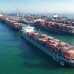 Vista aérea do Porto de Santos com navios cargueiros e contêineres, representando exportações brasileiras recorde de US$ 348,7 bilhões em 2025.