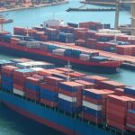 Porto brasileiro com navios e contêineres representando recorde de exportações de US$ 348,7 bilhões em 2025.