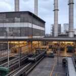 Fábrica industrial no Brasil com máquinas paradas, representando queda de 1,2% na produção em dezembro de 2025, segundo IBGE.