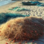 Barcos de pesca ancorados em praia nordestina brasileira, simbolizando cancelamento de licenças de pescadores profissionais.