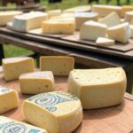 Variedades de queijo brasileiro em mesa rústica de fazenda mineira, sugerindo benefícios contra demência.