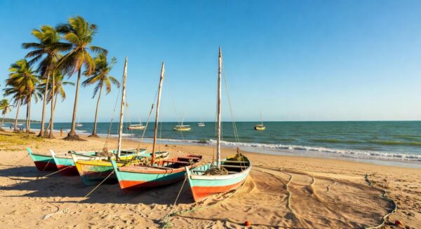 Barcos de pesca artesanal em praia brasileira, simbolizando bolsas de estudo para jovens pescadores pelo Ministério da Pesca.