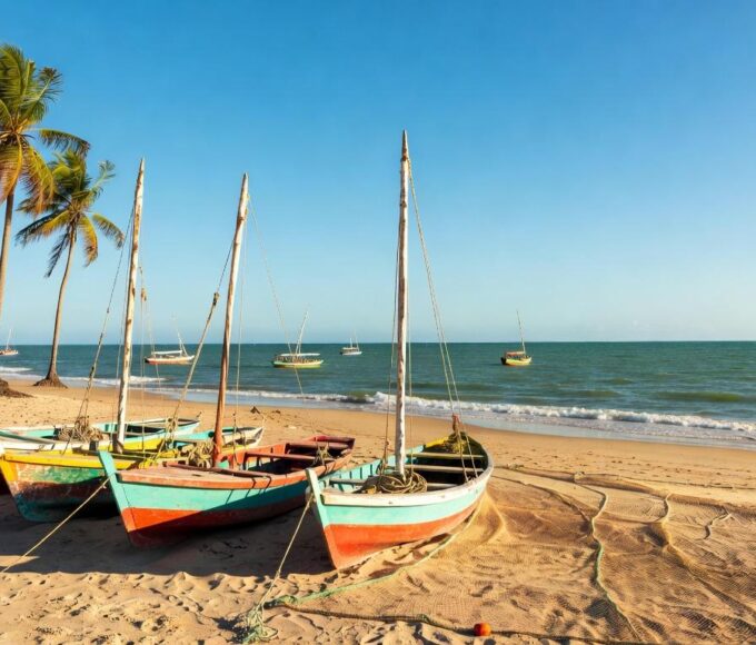 Barcos de pesca artesanal em praia brasileira, simbolizando bolsas de estudo para jovens pescadores pelo Ministério da Pesca.