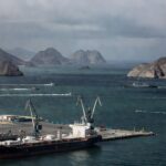 Navios no Estreito de Ormuz durante exercícios navais do Irã, afetando exportações de ureia para agricultura no Brasil.