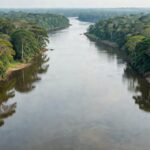 Hidrovia natural em rio da Floresta Amazônica brasileira, com densa vegetação tropical ao redor.