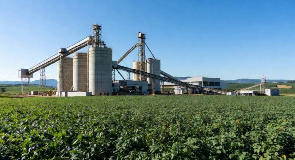 Instalação industrial de esmagamento de soja em Ponta Grossa, com campos de plantação ao fundo.