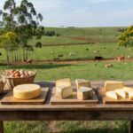 Mesa com queijos artesanais e ovos caipiras em fazenda de Aracatuba, simbolizando selo Sisbi-POA para venda nacional.