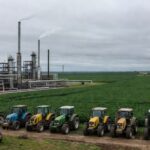 Refinaria de petróleo no RS com campos de soja ao fundo, alertando para possível desabastecimento de diesel.