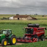 Feira agrícola Expodireto Cotrijal com estandes de máquinas e campos de cultivo sob céu nublado, debatendo clima e mercado.