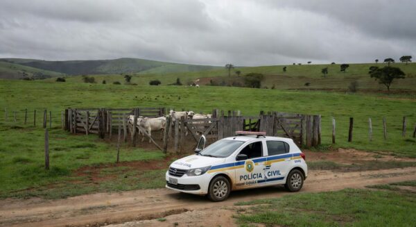 Viatura da Polícia Civil de Goiás em fazenda com gado, representando investigação de golpe em revenda de animais.