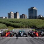 Pista de Fórmula 1 em Interlagos com carros e plantações de cana simbolizando combustível sustentável para 2026.