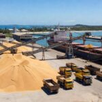 Porto brasileiro com navios carregando DDG para exportação à China, produção em alta.