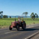 Máquina agrícola transitando em rodovia pública em área rural de São Paulo, Brasil.