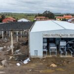 Fábrica industrial no RS após enchentes, com investimentos para retomada de operações.