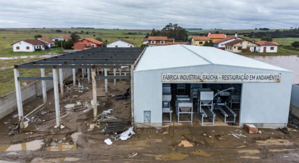 Fábrica industrial no RS após enchentes, com investimentos para retomada de operações.